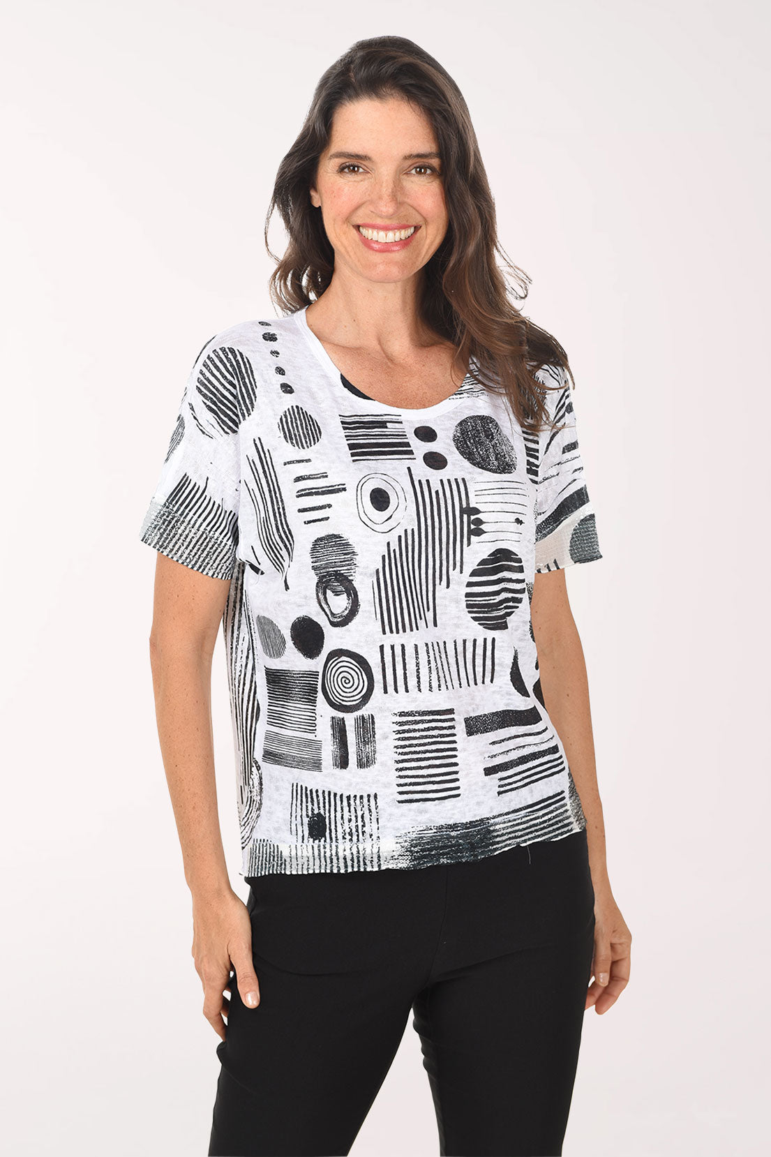 Woman wearing a black and white abstract patterned top on a white background