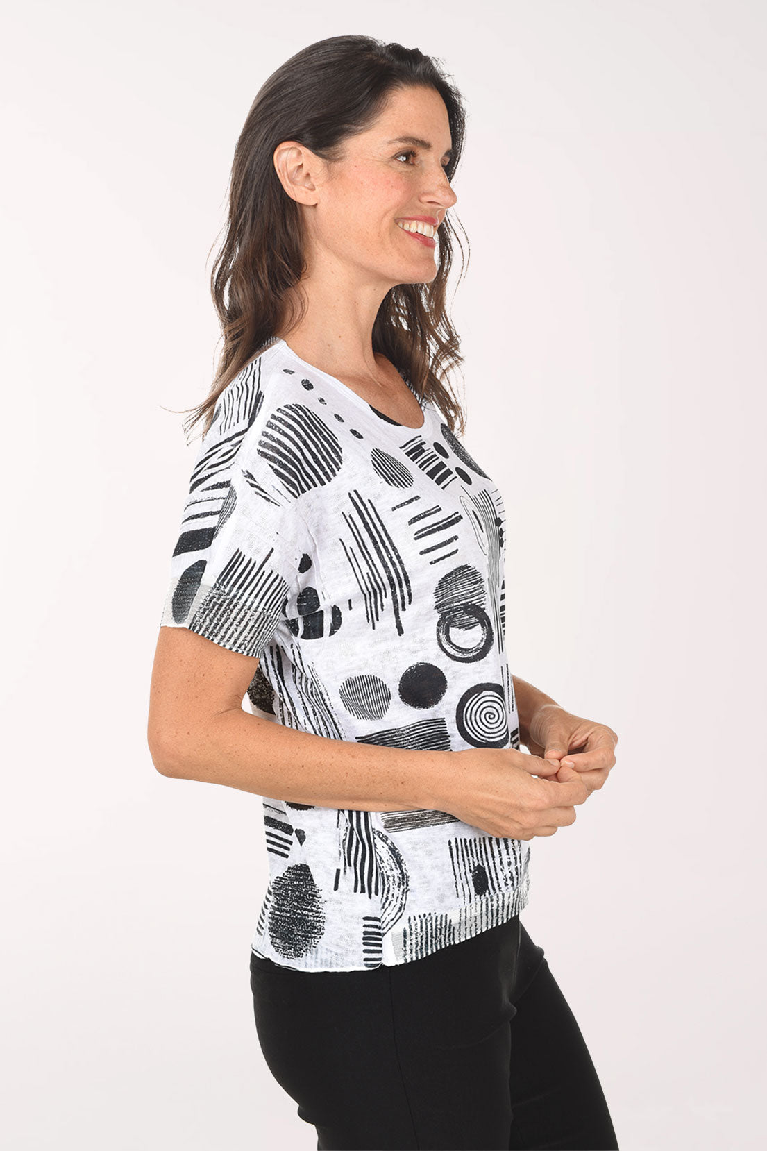 Woman wearing a black and white abstract patterned top on a white background