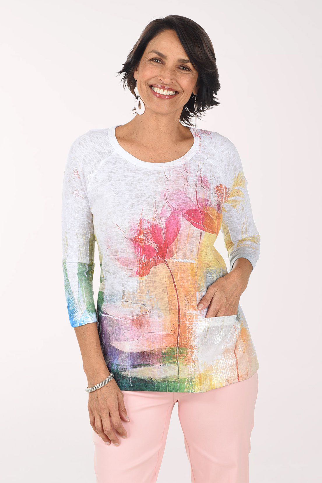 Woman wearing a colorful floral-patterned top on a white background