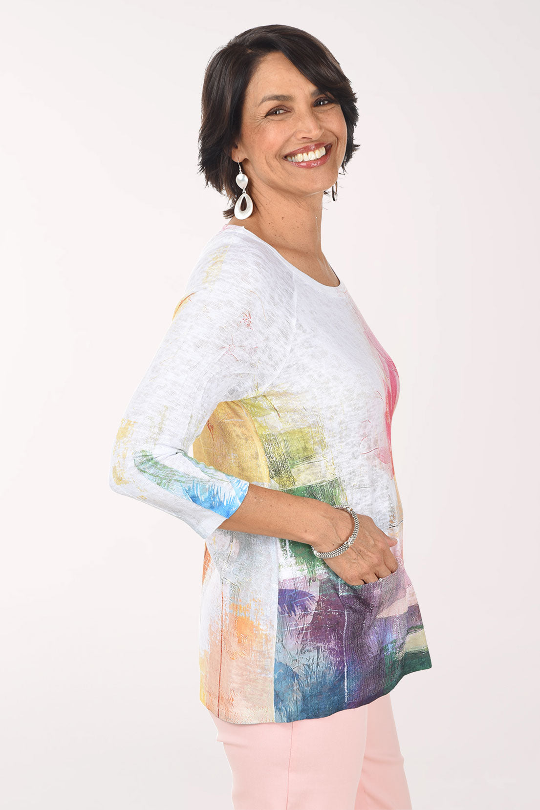 Woman wearing a colorful floral-patterned top on a white background