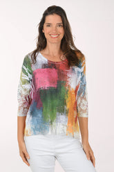 Woman wearing a colorful, patterned top on a white background