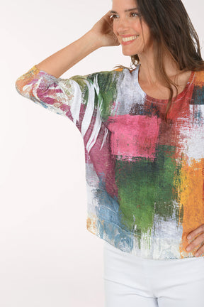 Woman wearing a colorful, patterned top on a white background