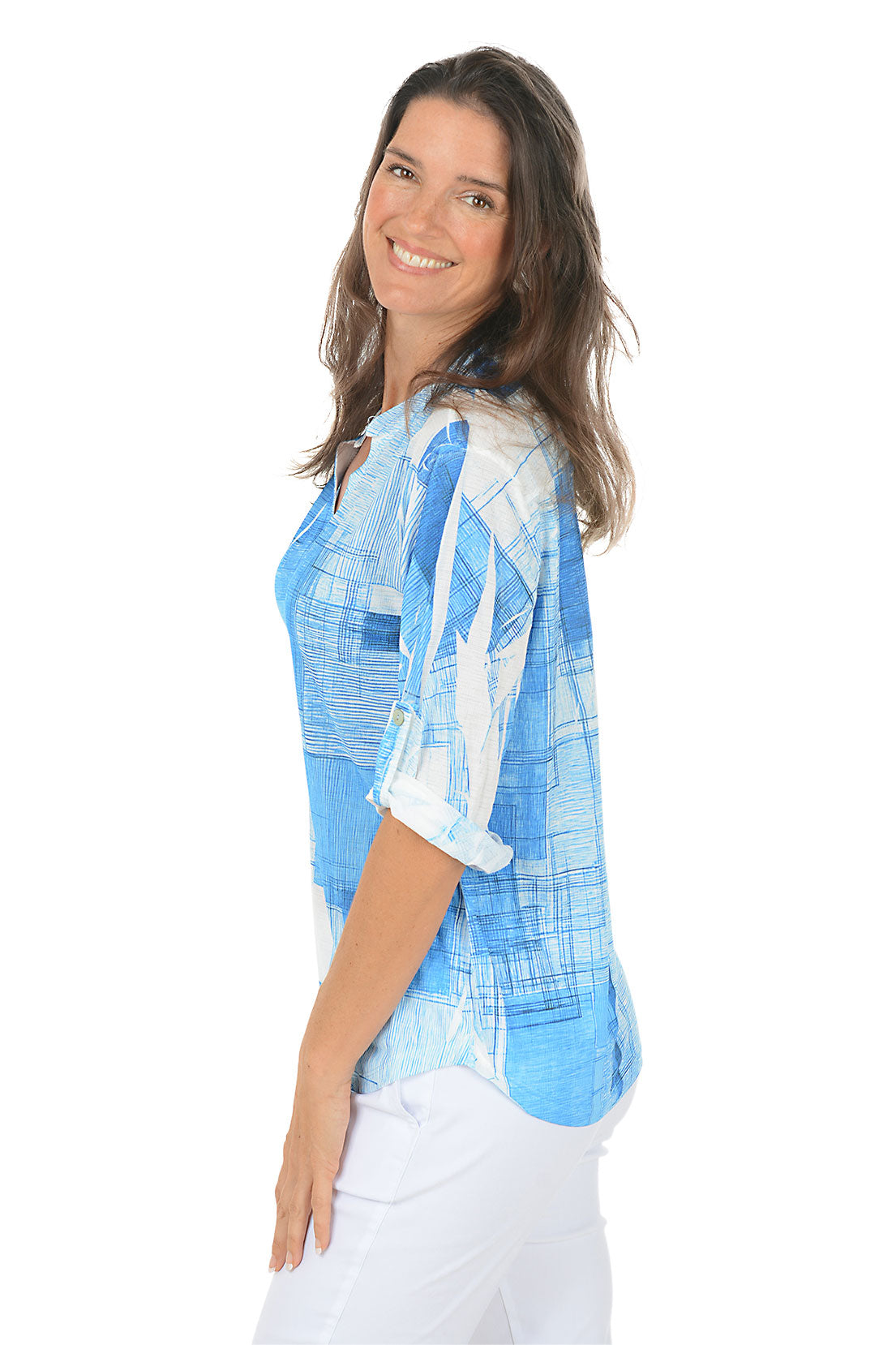Woman wearing a blue abstract patterned shirt on a white background. Side shot.