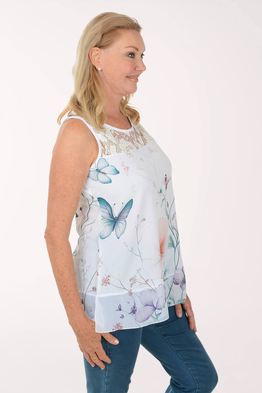 Woman wearing a sleeveless top with butterfly design on a white background