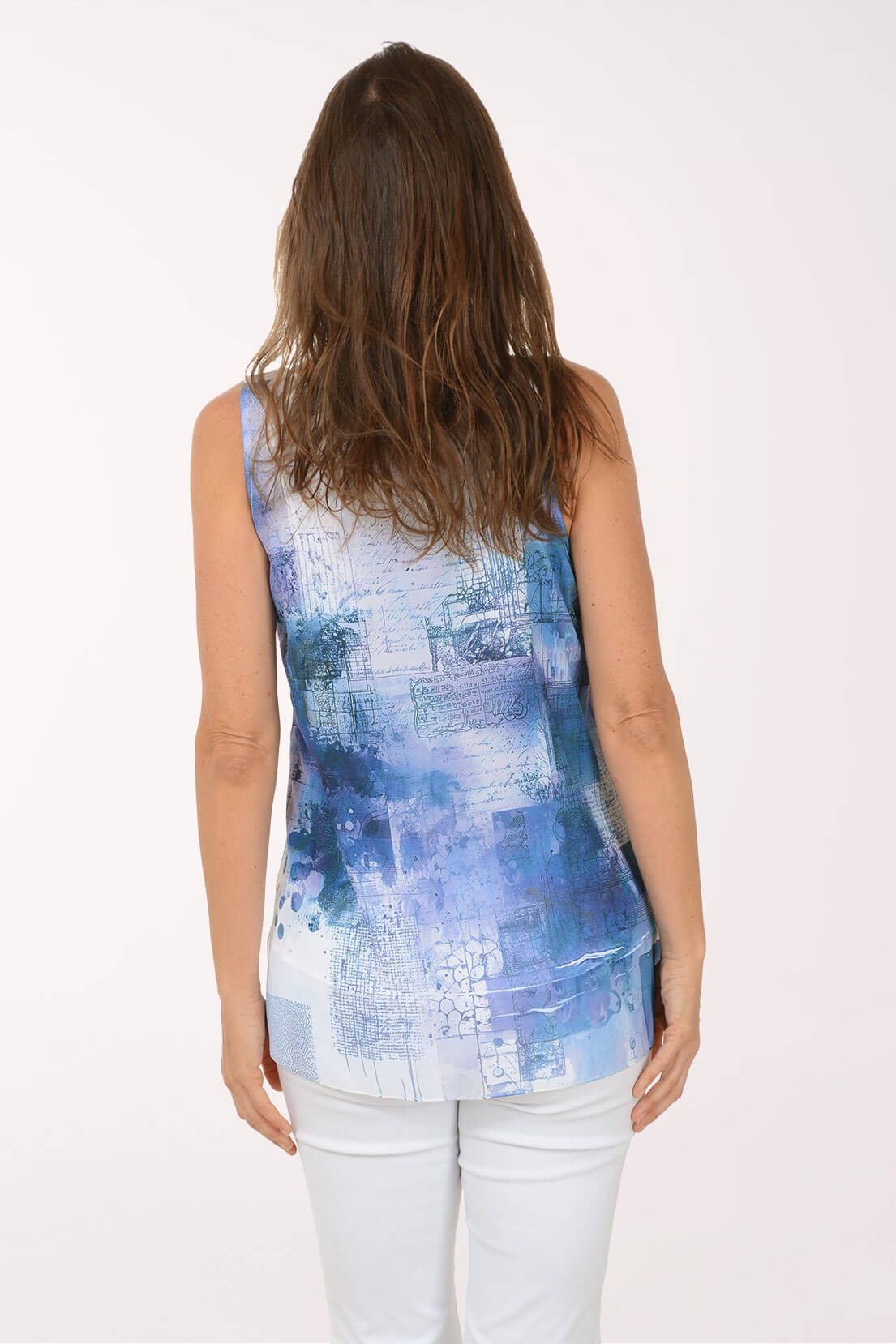Woman wearing a sleeveless blue and white patterned top on a white background