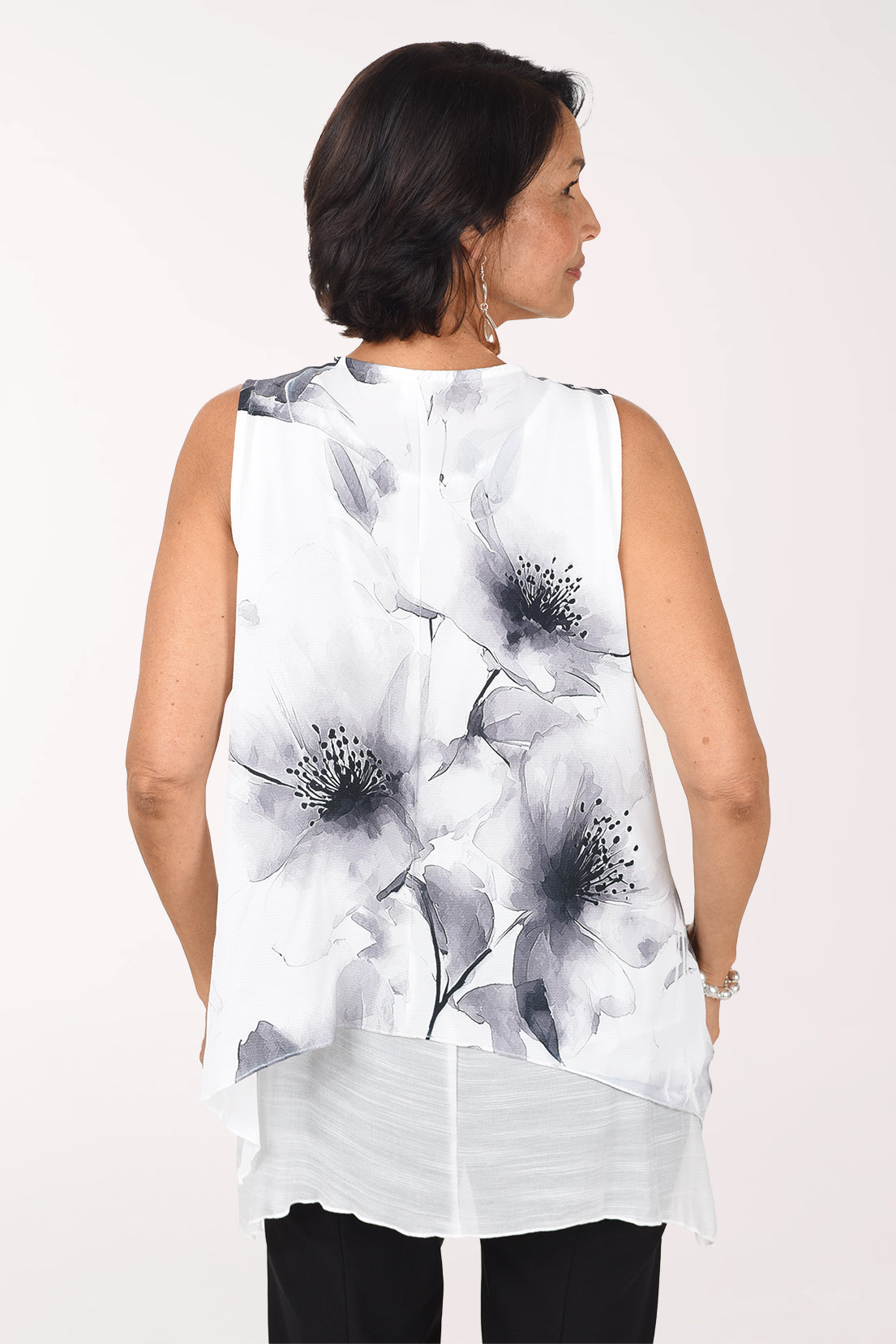 Back view of the Silver Petals blouse showing grey watercolor flowers across the back and the inner tank peeking below the hem.