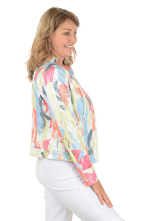 Woman wearing a colorful jacket over a white shirt and pants on a white background. Side shot.