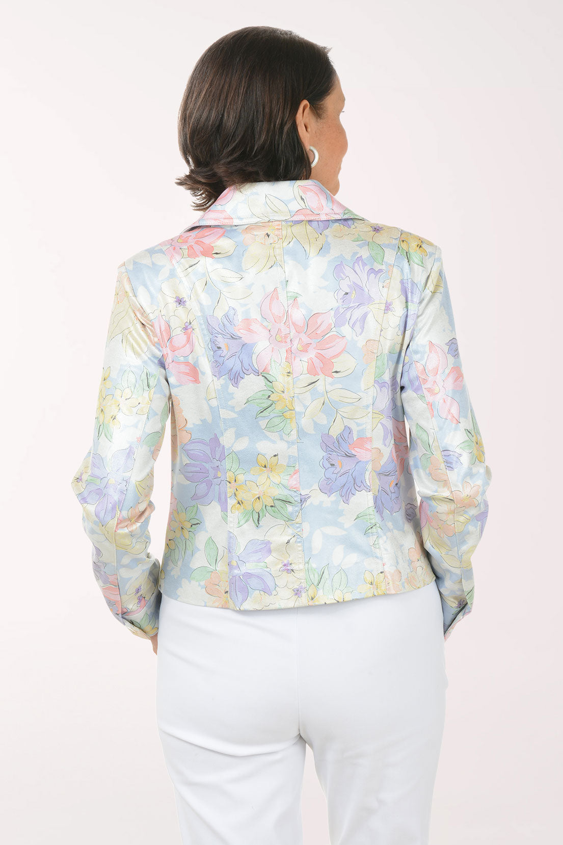 Woman wearing a pastel floral jacket on a white background