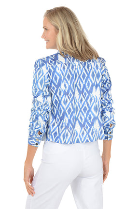 Woman wearing a blue and white patterned jacket on a white background. Back shot.