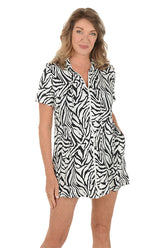 A woman wearing a black and white short sleeve zippered cover-up.