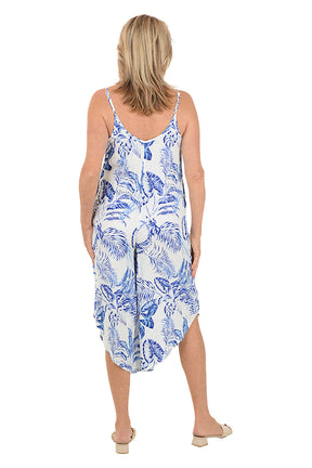 Woman wearing a blue and white floral dress on a white background. Back shot.