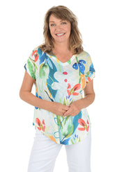 A woman wearing a short sleeve v-neck top with a tropical floral motif.