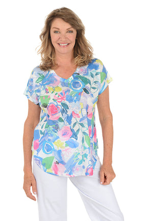 Woman wearing a white short sleeve v-neck shirt with a floral design.
