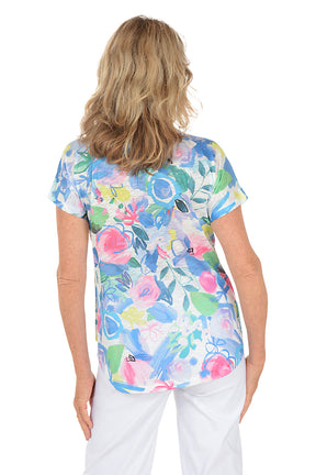 Woman wearing a white short sleeve v-neck shirt with a floral design. Back shot.