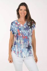 Woman wearing a colorful star-patterned top on a white background