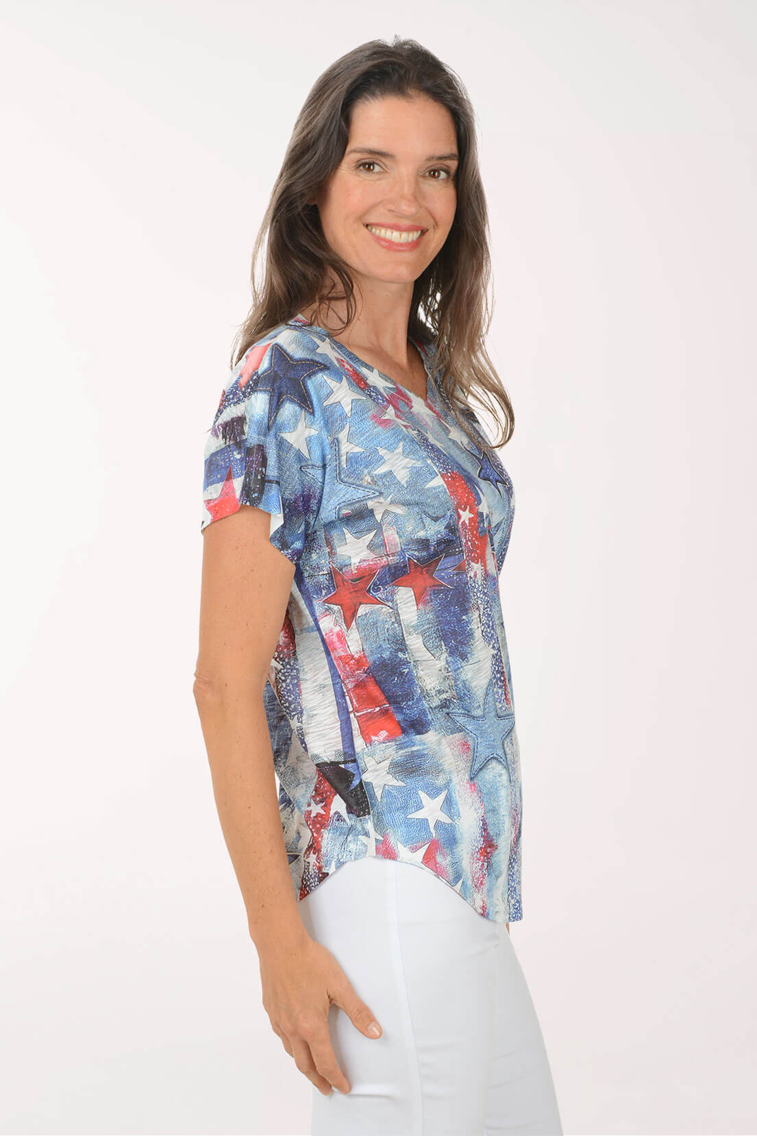 Woman wearing a colorful star-patterned top on a white background