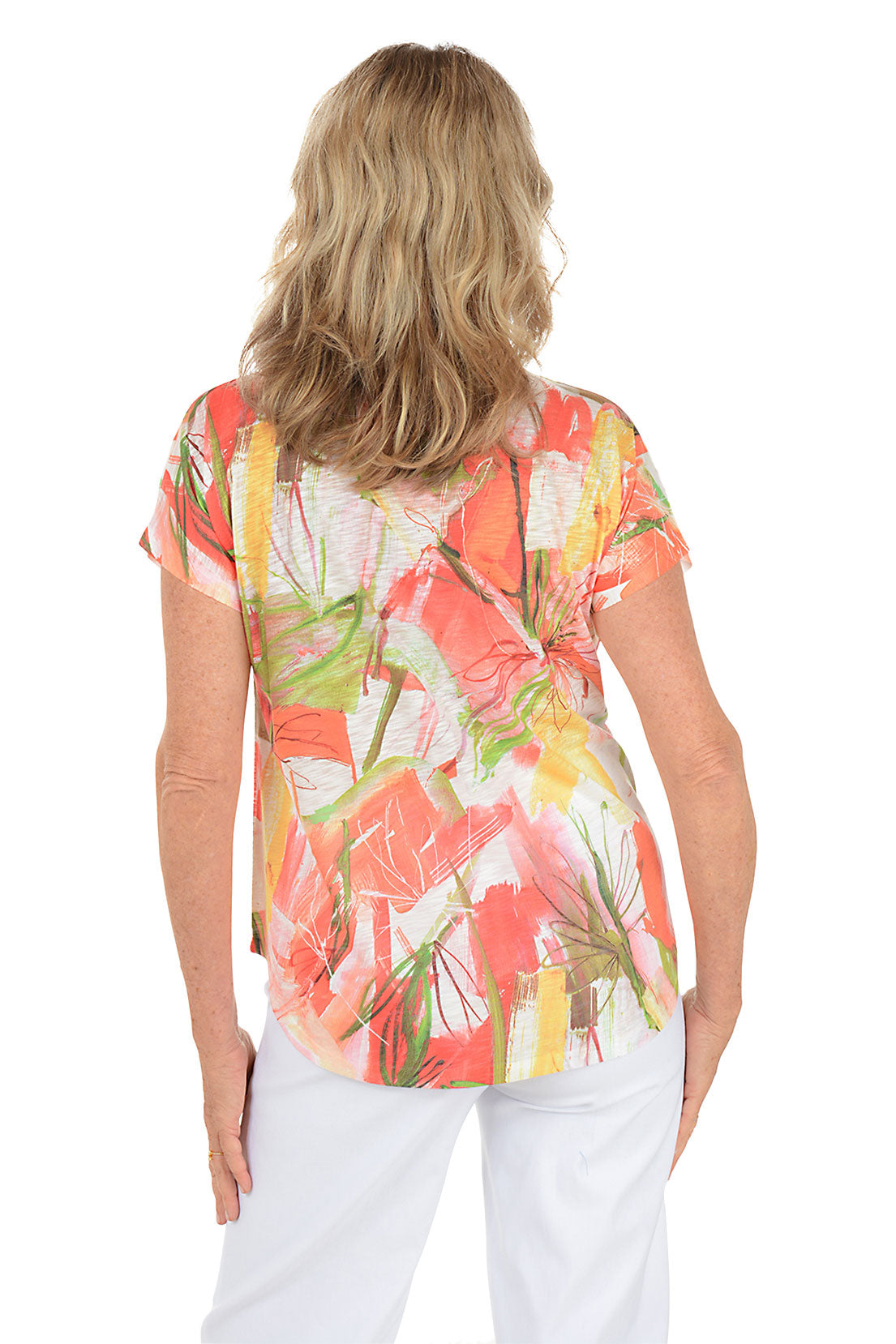 A woman wearing a multi-colored short sleeve v-neck shirt with a floral design. Back shot.