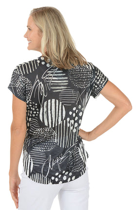 Woman wearing a black and white patterned top on a white background. Back shot.