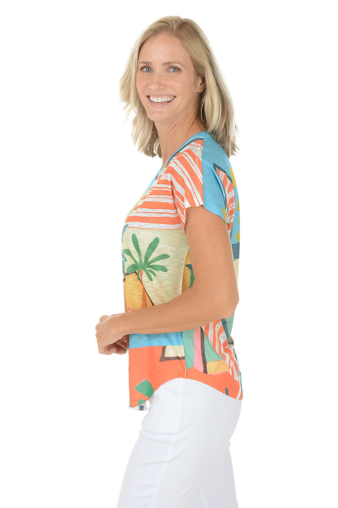 A woman wearing a multicolored short sleeve v-neck shirt with a landscape design. Side shot.
