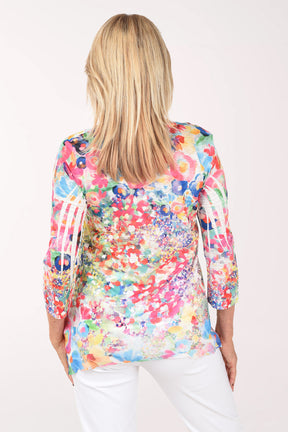 Woman wearing a colorful floral blouse against a white background
