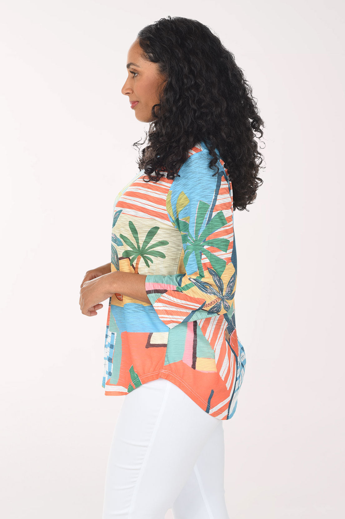Woman wearing a colorful patterned shirt with palm tree design on a white background
