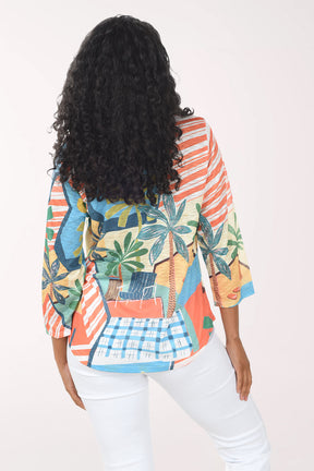 Woman wearing a colorful patterned shirt with palm tree design on a white background