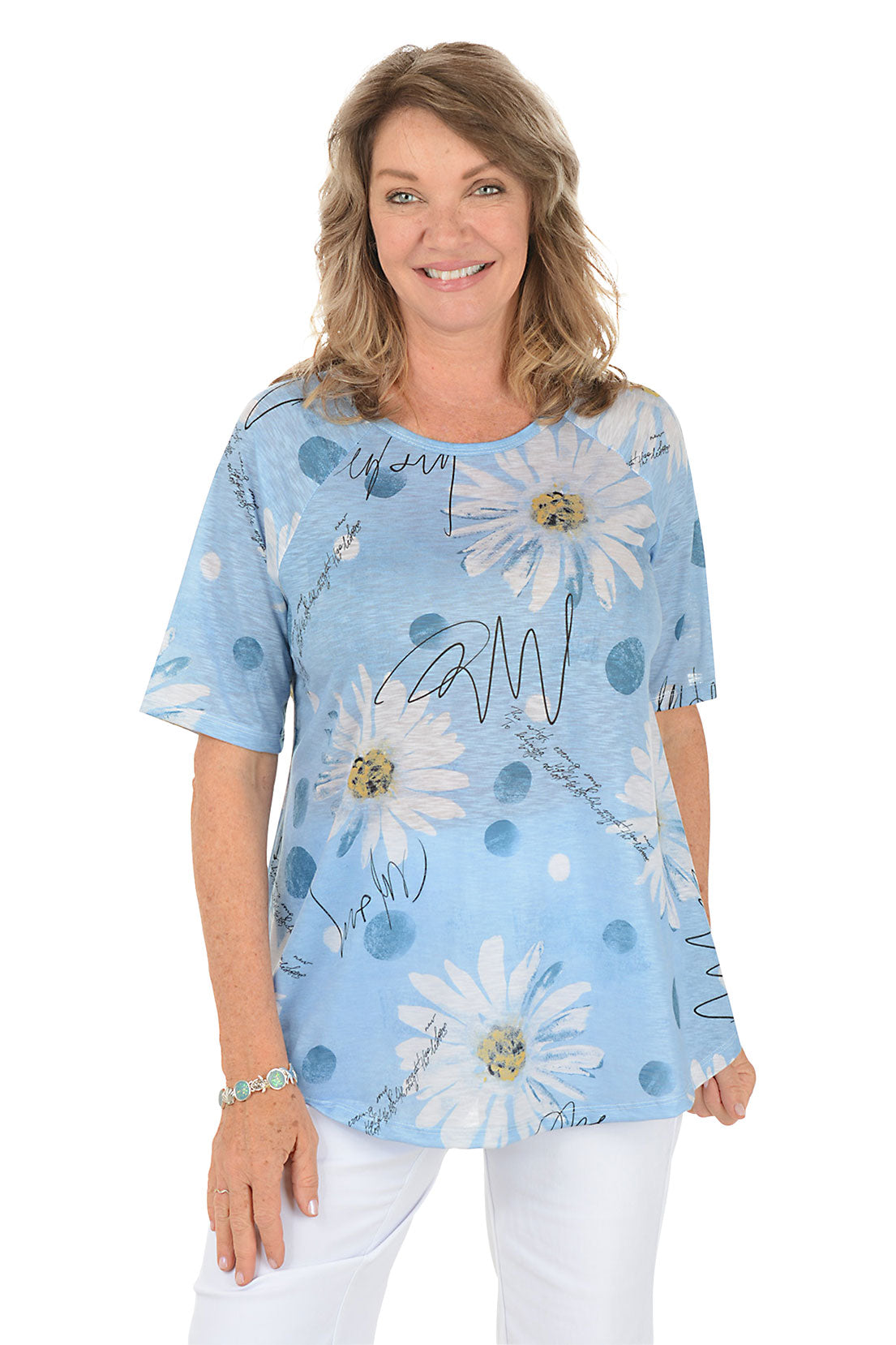 A woman wearing a blue short sleeve shirt with a daisy pattern.