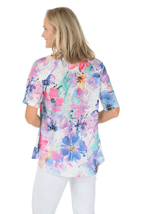A woman wearing a purple short sleeve shirt with a floral pattern. Back shot.