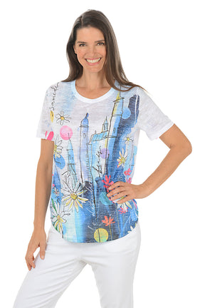 Woman wearing a colorful graphic t-shirt with a white background.