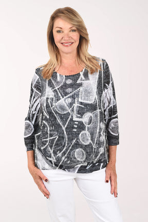 Woman wearing a black and white patterned top on a white background