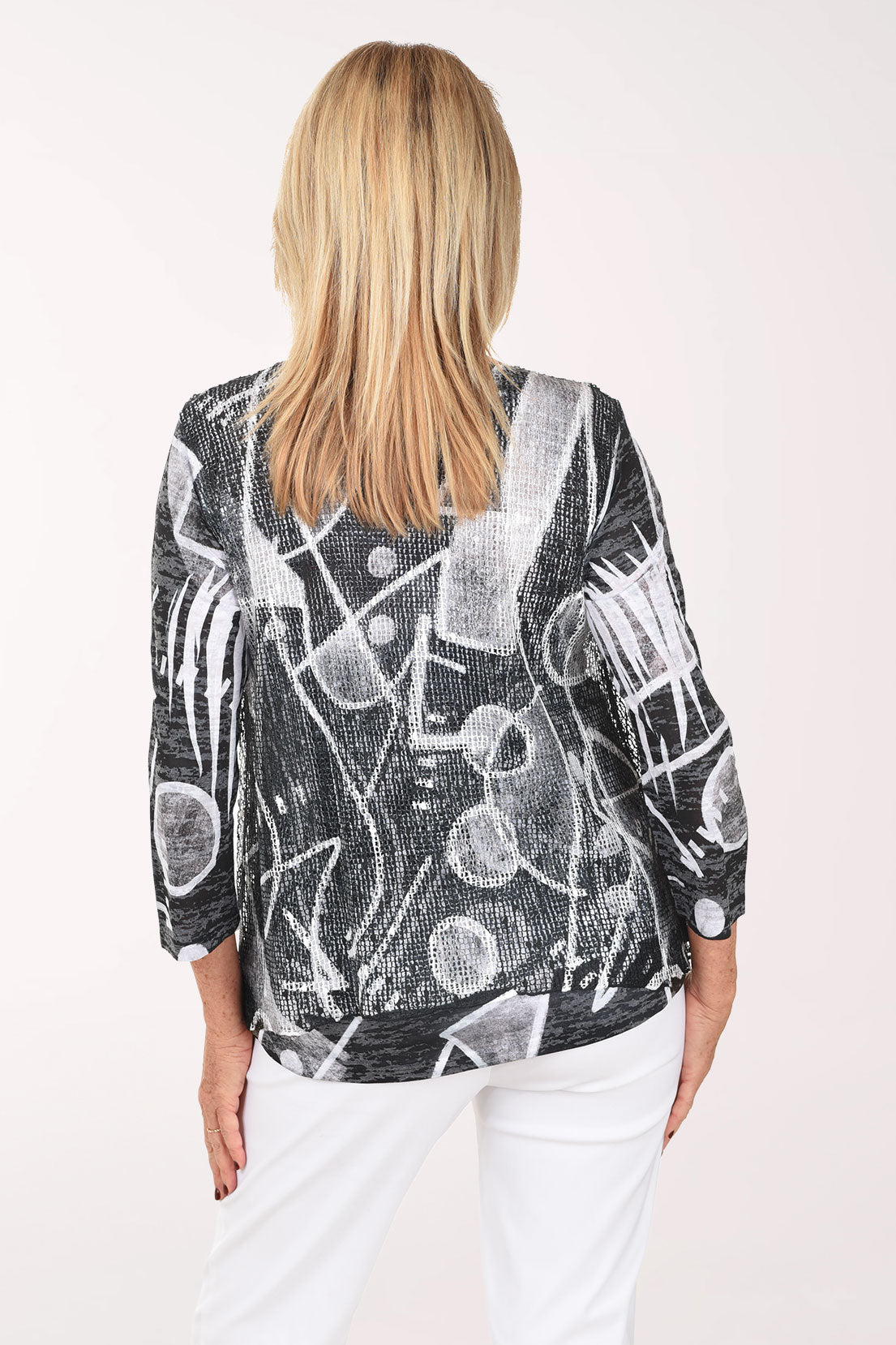 Woman wearing a black and white patterned top on a white background