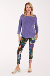 Woman wearing purple shirt and abstract printed leggings