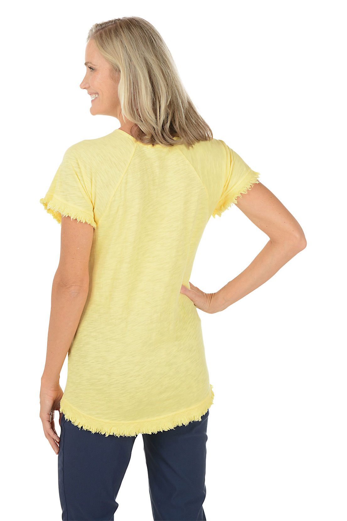 A woman wearing a short sleeve yellow shirt with a floral pattern. Back shot.