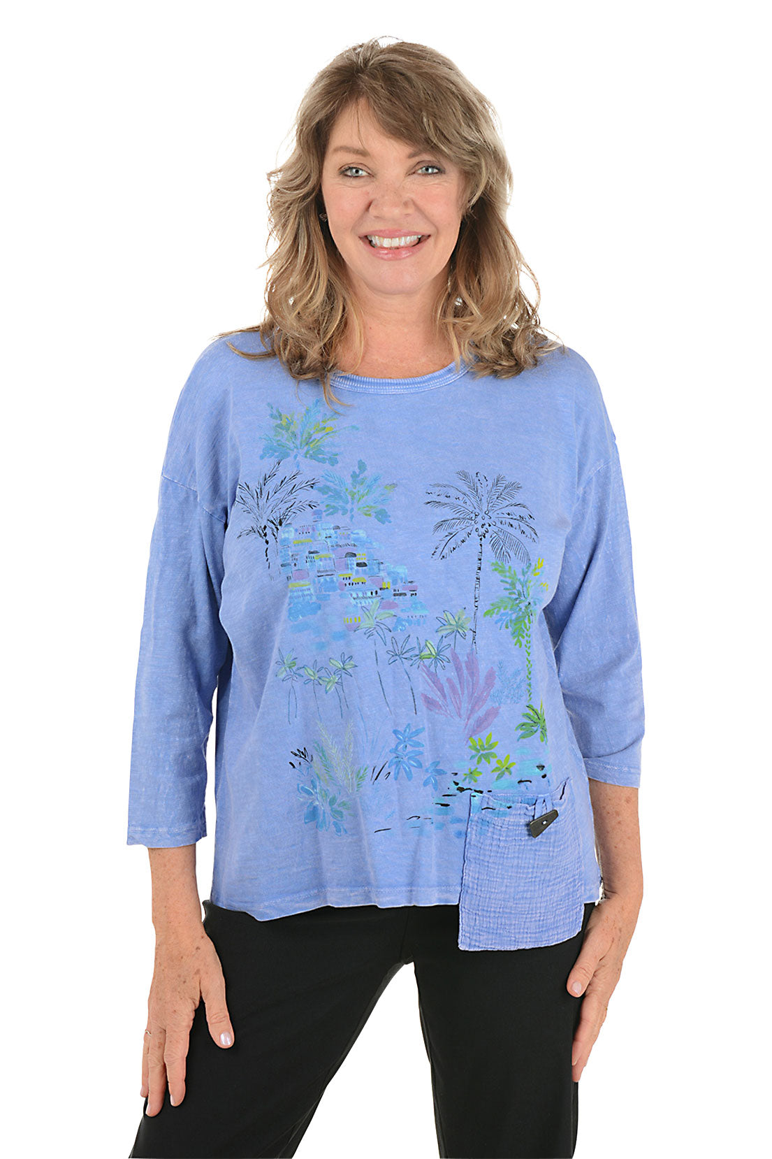 A woman wearing a 3/4 sleeve blue top with a palm tree pattern detail.