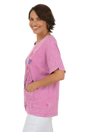 Woman wearing a pink floral-patterned shirt on a white background