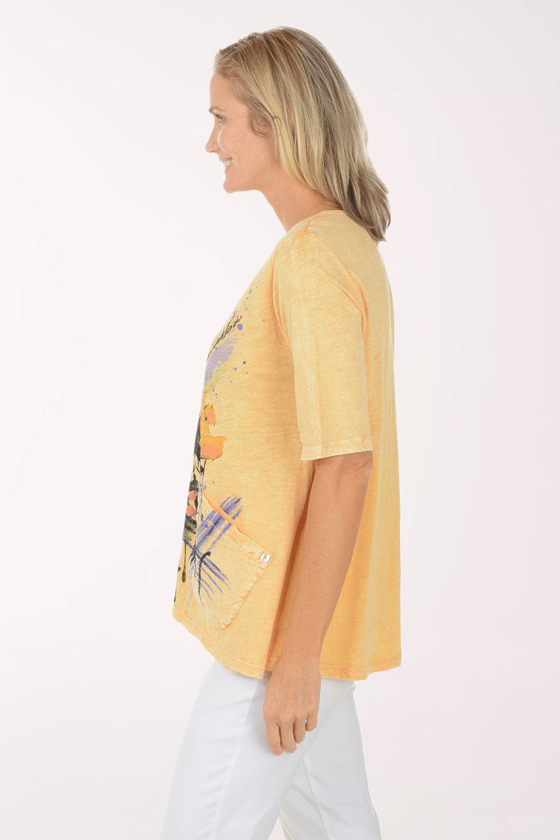 Woman wearing a yellow t-shirt with floral design on a white background