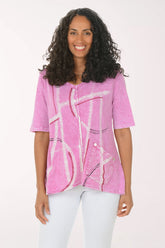 Woman wearing a pink abstract patterned top on a white background