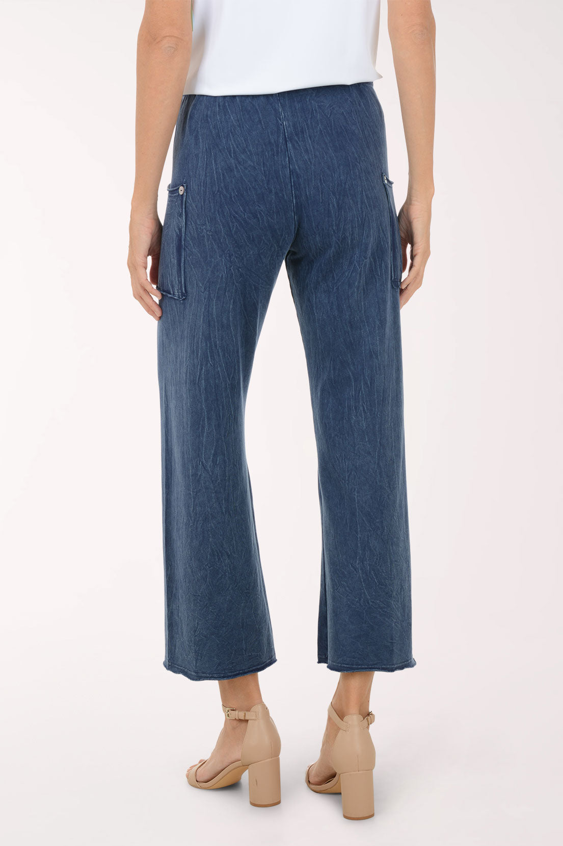 Blue denim pants worn by a person on a white background