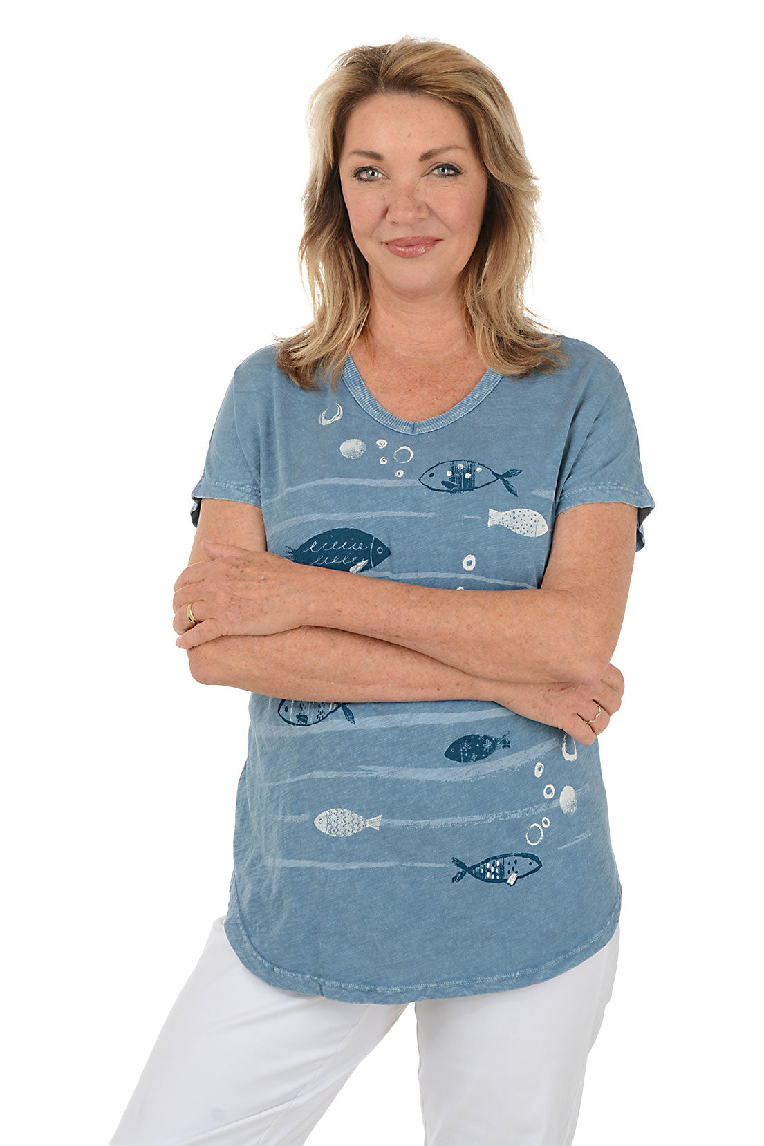Woman wearing a blue t-shirt with fish designs on a white background. Second front shot.