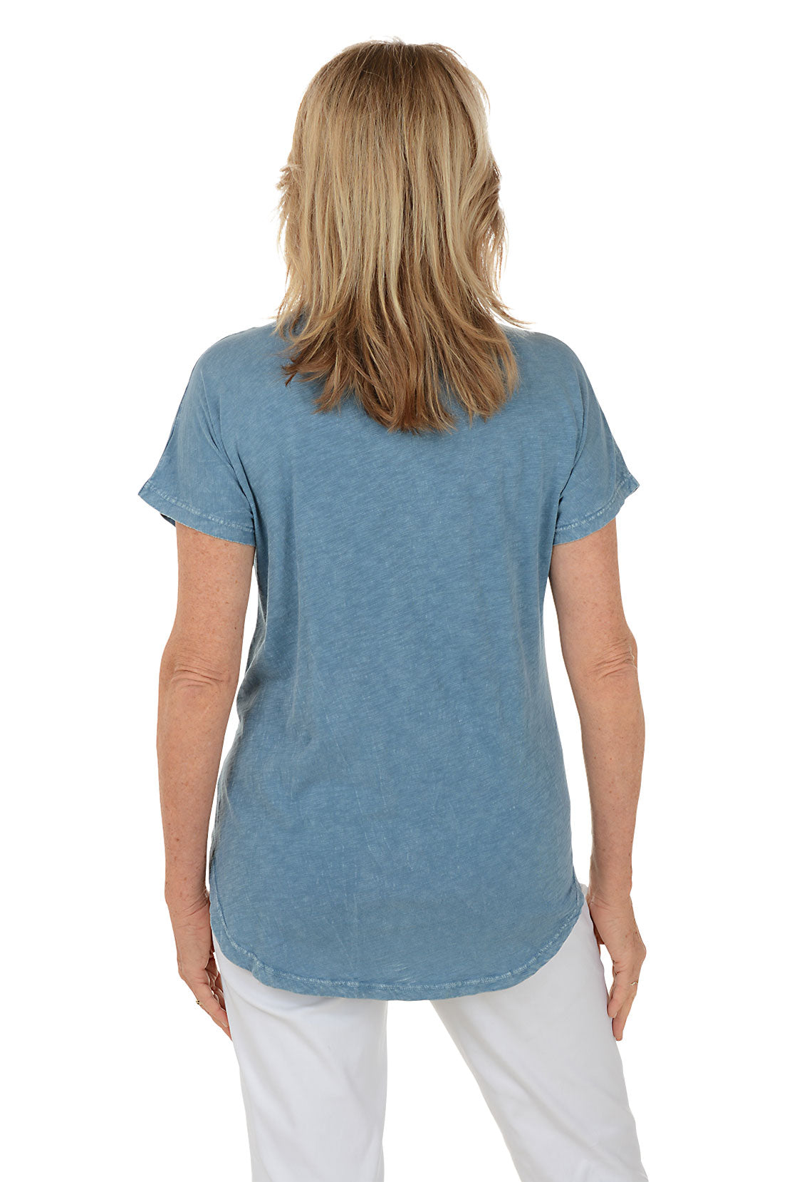 Woman wearing a blue t-shirt with fish designs on a white background. Back shot.