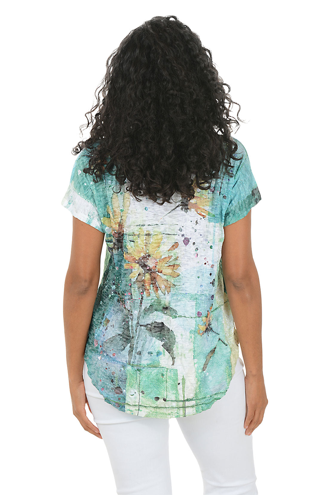 Woman wearing a floral-patterned top and white pants on a white background.Back shot.