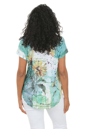 Woman wearing a floral-patterned top and white pants on a white background.Back shot.