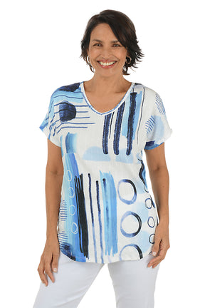 Woman wearing a blue and white abstract patterned top on a white background