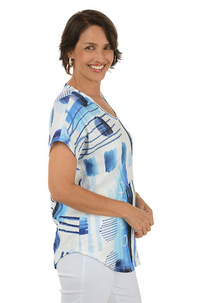 Woman wearing a blue and white abstract patterned top on a white background