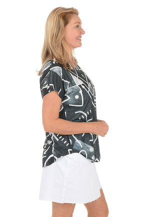 Woman wearing a black t-shirt with white abstract patterns on a white background. Side shot.