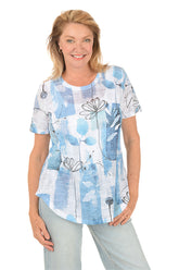 Woman wearing a blue floral patterned shirt on a white background.