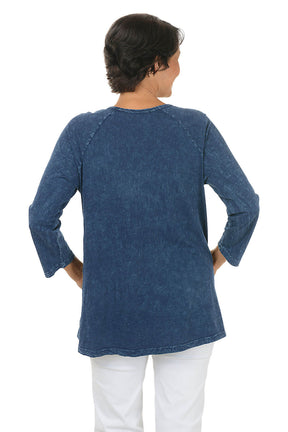 A back shot of a model wearing a blue denim-style long-sleeve top on a white background