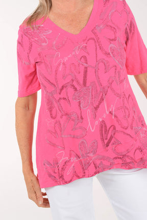Woman wearing a pink blouse with floral patterns on a white background