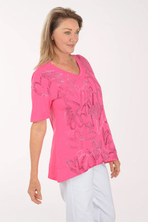 Woman wearing a pink blouse with floral patterns on a white background