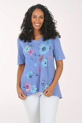 Woman wearing a blue floral tunic against a white background